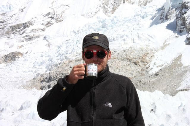 Niklas dricker andäktigt sitt kaffe ur sin Hi On Life mugg i Everest BC